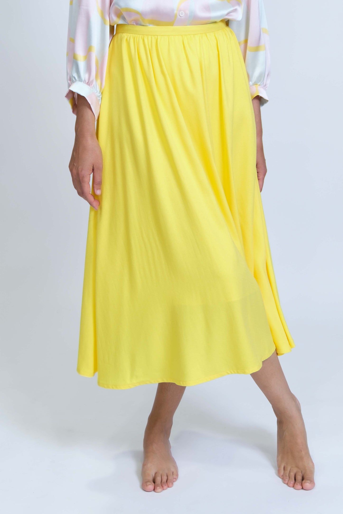 Jupe longueur midi froncée à la taille, réalisée à la main en petite série, en crêpe de viscose jaune citron, vue rapprochée de face, détail texture et fluidité du tissu.