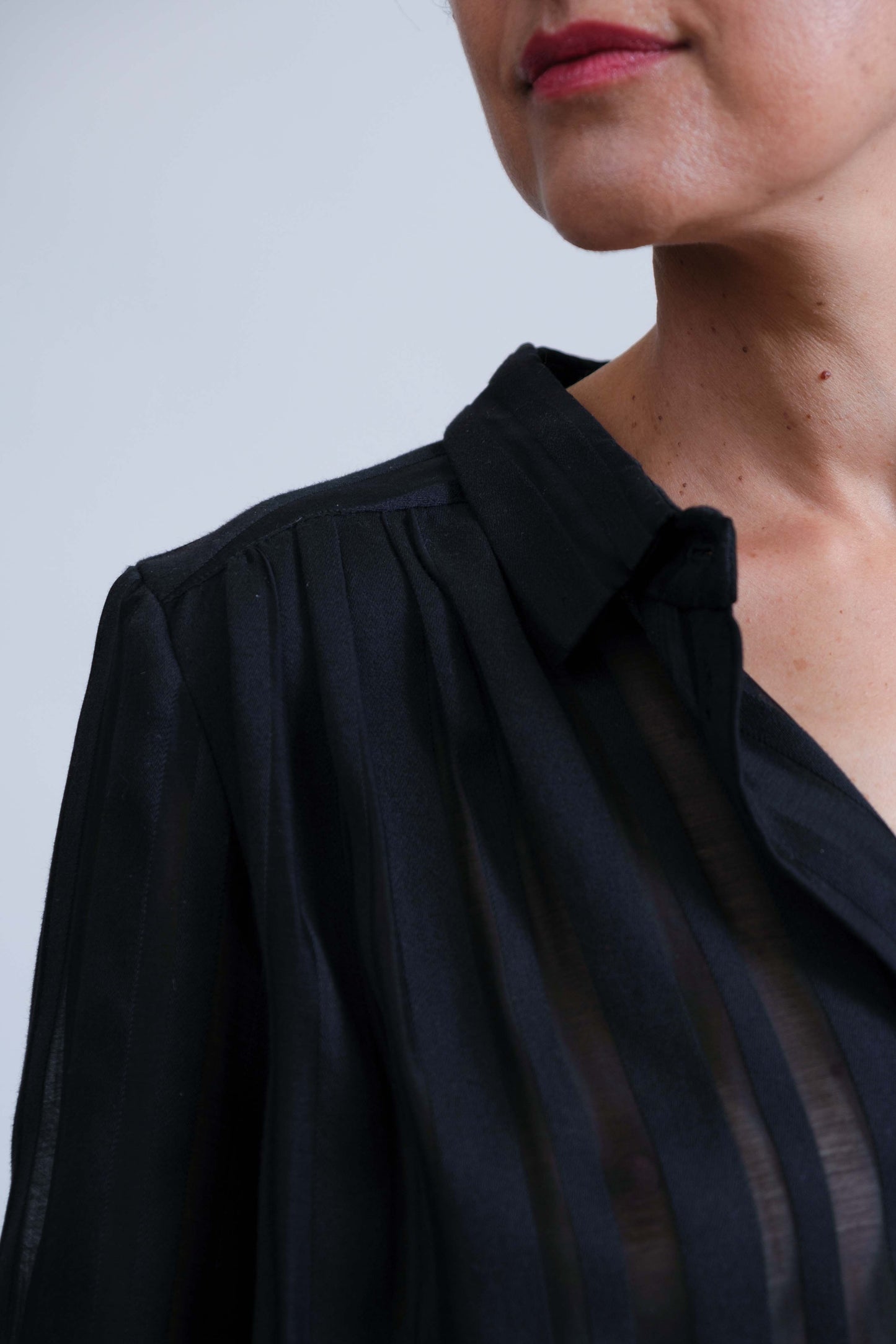 Chemise femme réalisée à la main, à rayures noires opaques et transparentes, détail col et patte de boutonnage.