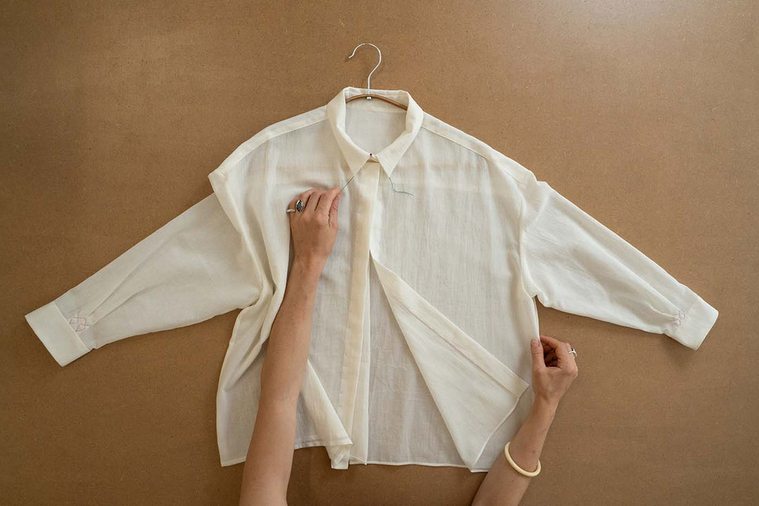 Chemise blanche en cours de montage sur une table de couture