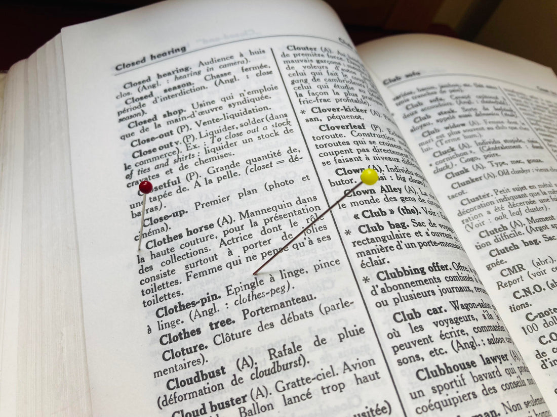 Dictionnaire anglais-français ouvert avec des épingles, pour illustrer le vocabulaire de couture