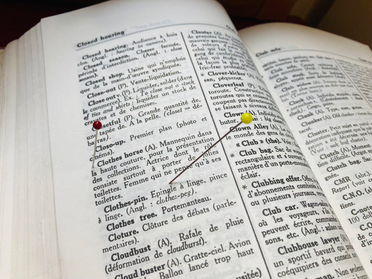 Dictionnaire anglais-français ouvert avec des épingles, pour illustrer le vocabulaire de couture