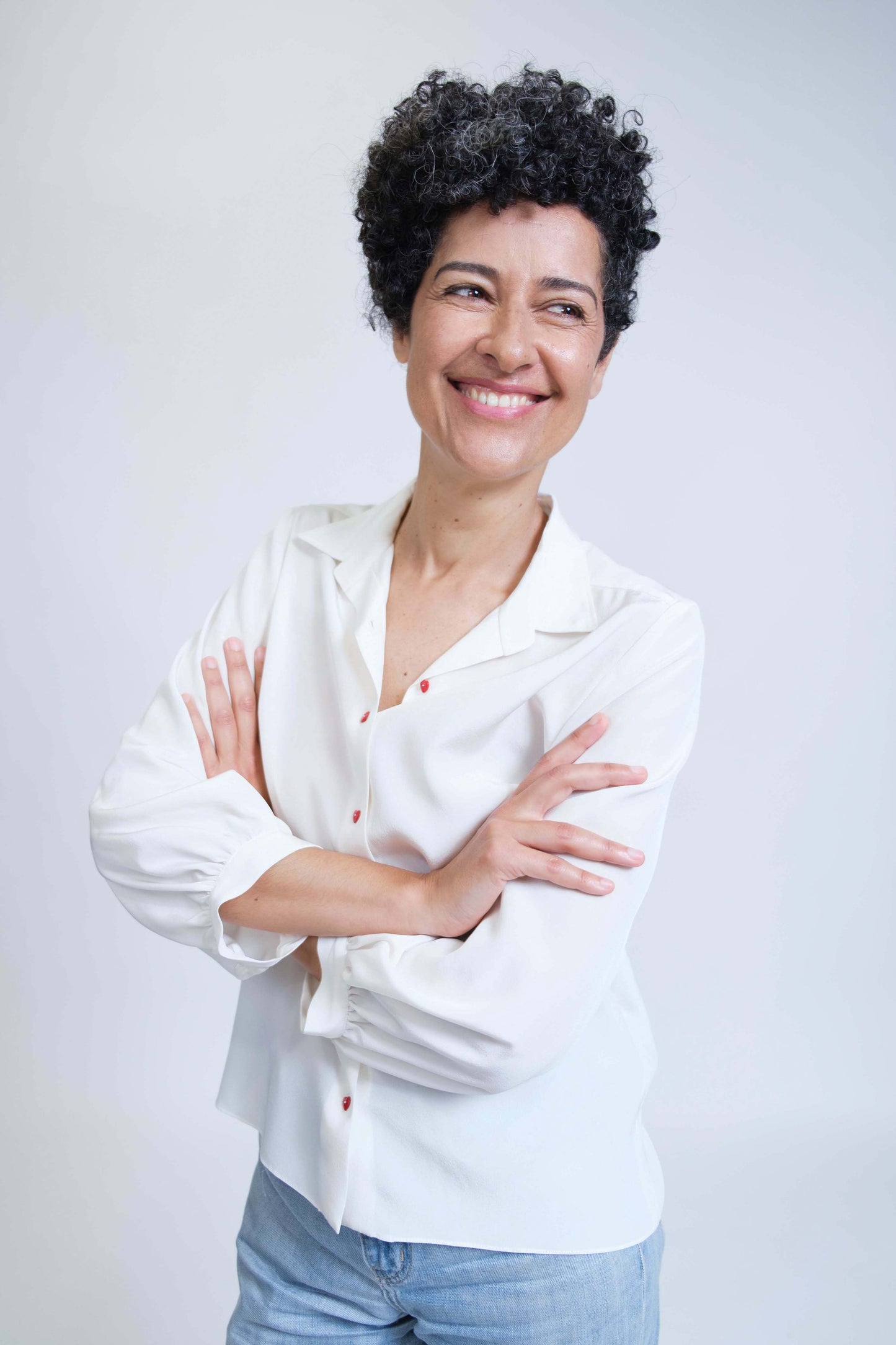 Chemise femme réalisée à la main en crêpe de soie blanc et ses boutons coeur rouges, vue rapprochée de face, détail col et manches.