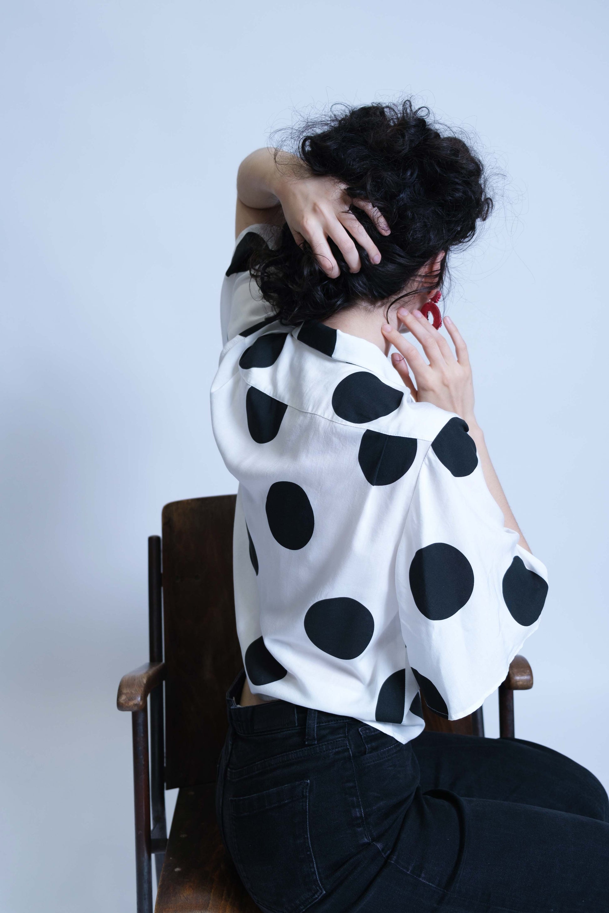 Chemisette pour femme réalisée à la main en deux exemplaires, en viscose blanche à gros pois noirs, vue trois quart dos, détail empiècement et plis de confort.