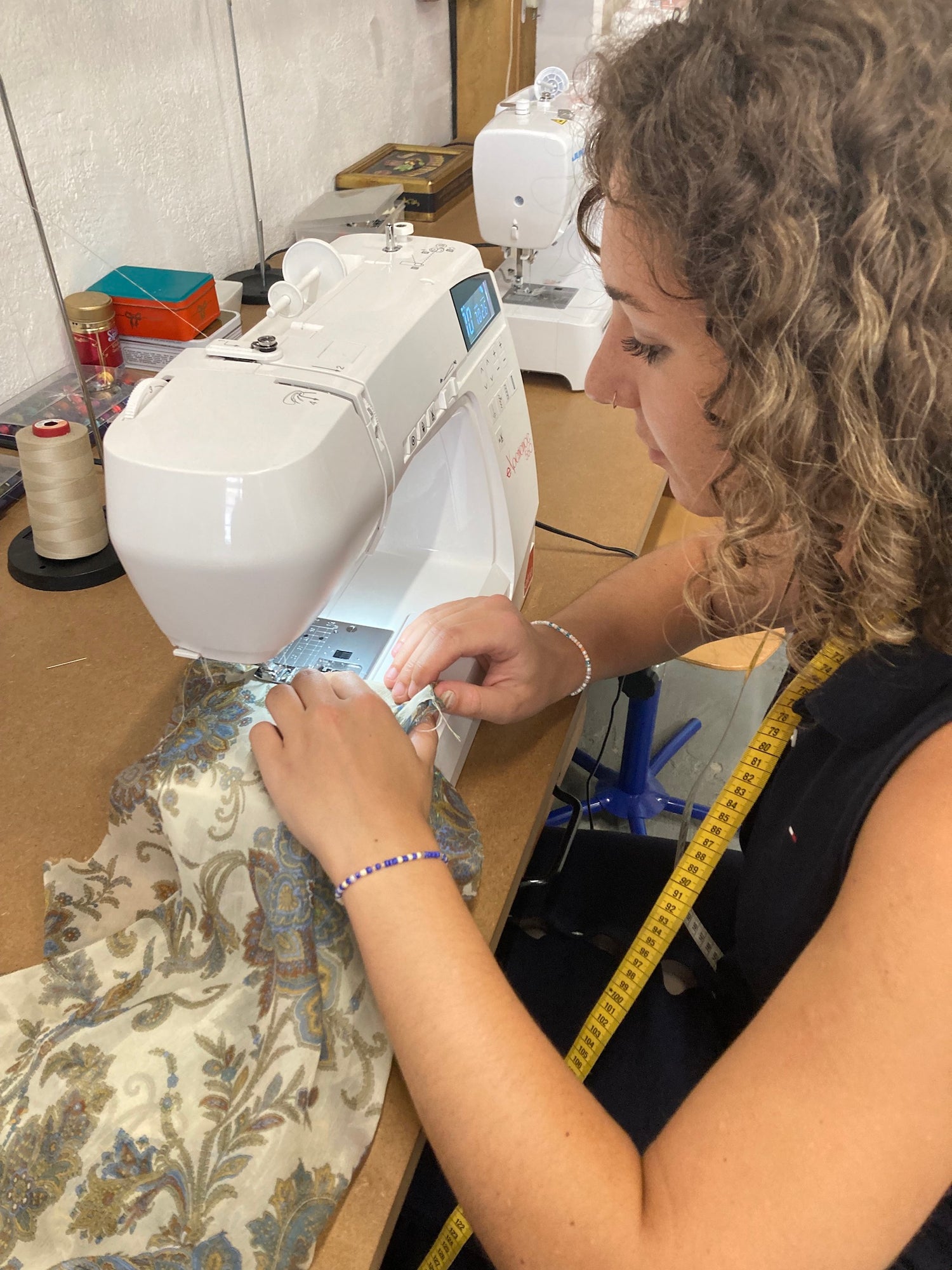 Élève apprenant à utiliser une machine à coudre pendant un cours de couture à Marseille.