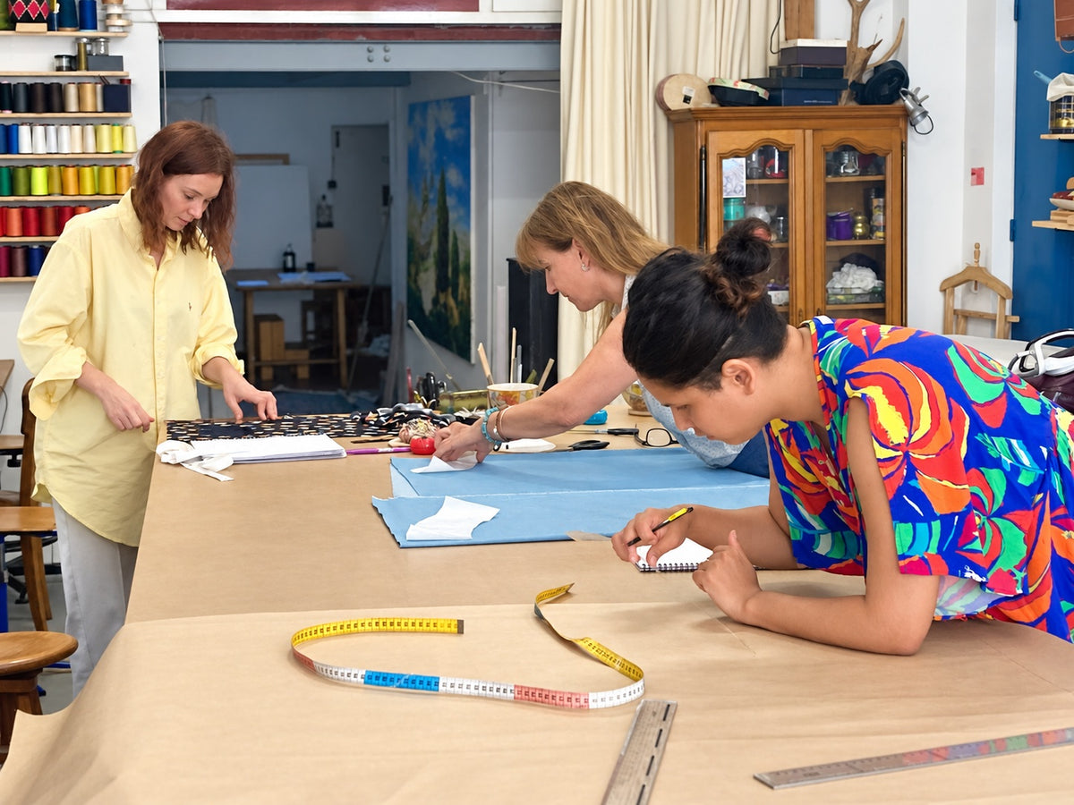 Trois élèves avancent sur des projets de couture différents dans l’atelier.